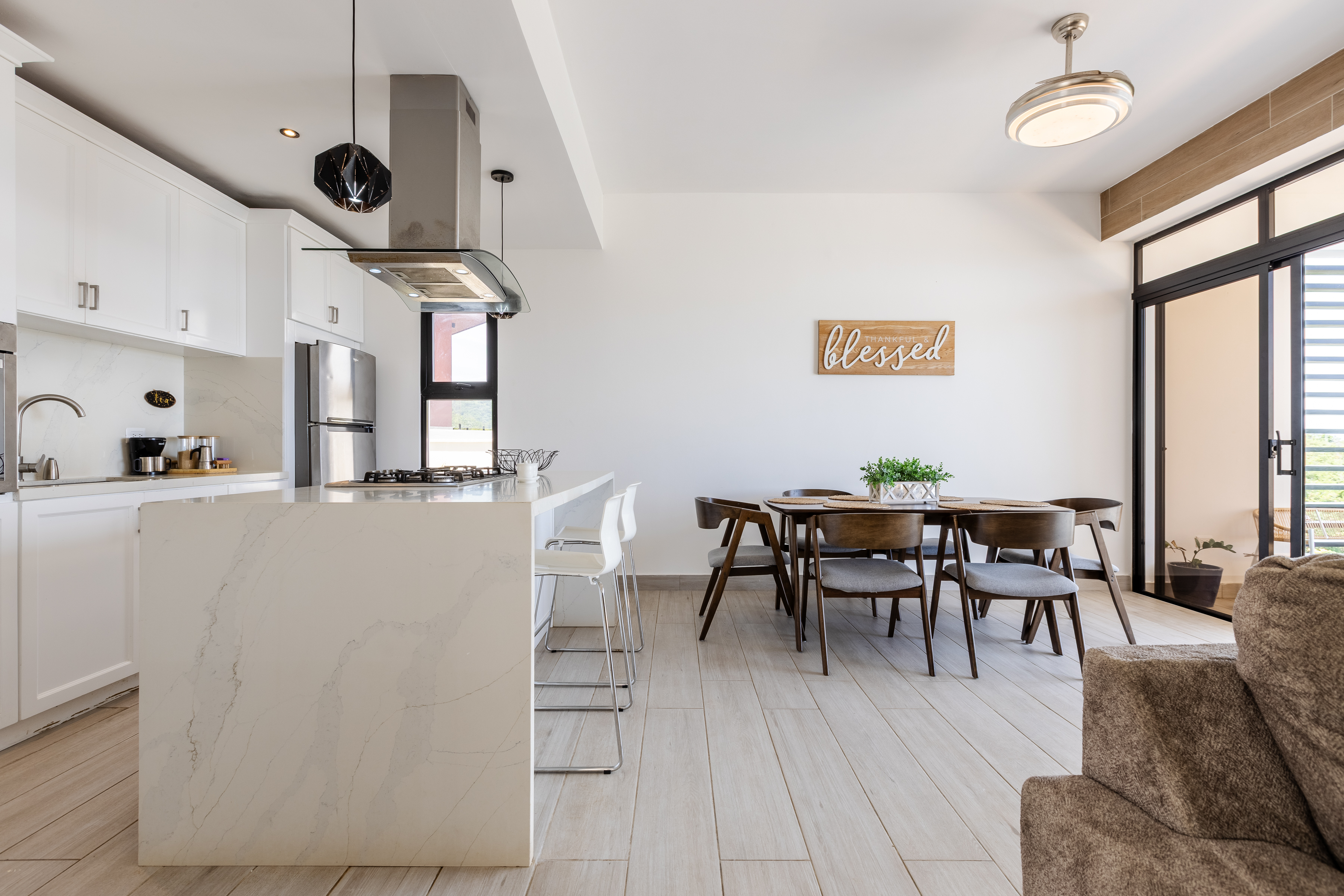 Kitchen marble island with dining table and terrace beyond