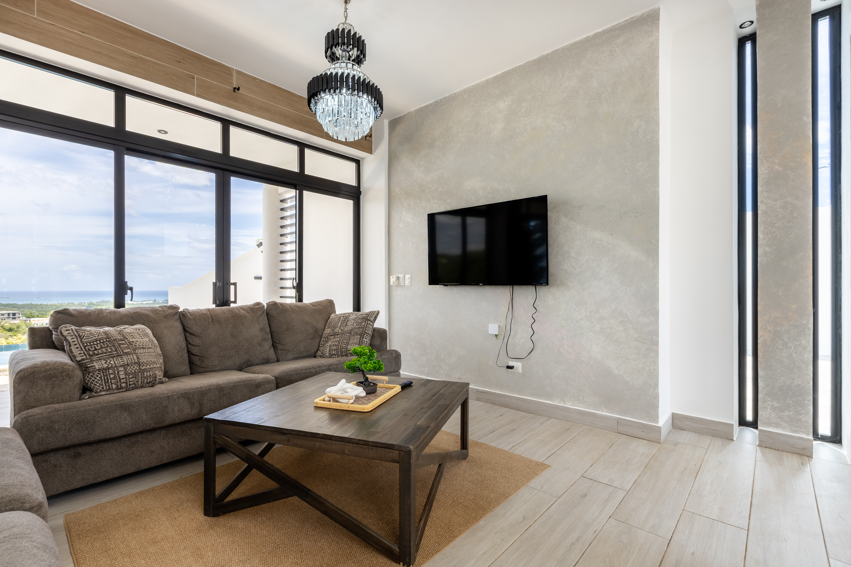 Living room with TV wall, chandelier and Caribbean light